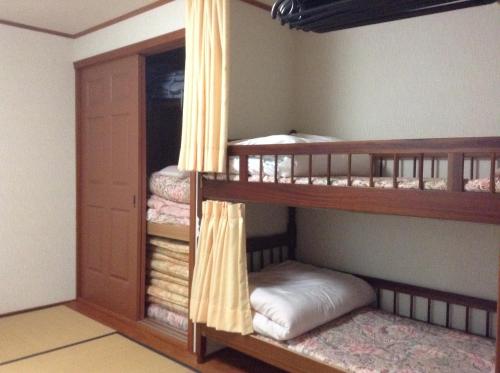 a room with two bunk beds in a room at Lodge Skade in Omachi