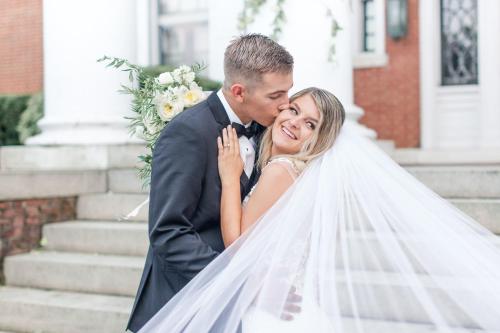 uma noiva e um noivo posam com o seu véu em Mercersburg Inn em Mercersburg