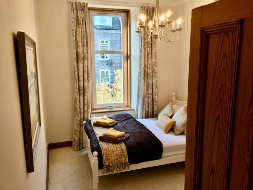 a bedroom with a bed in front of a window at Cosy 2 Bedroom Central Apartment - Free Parking, Free WiFi in Aberdeen