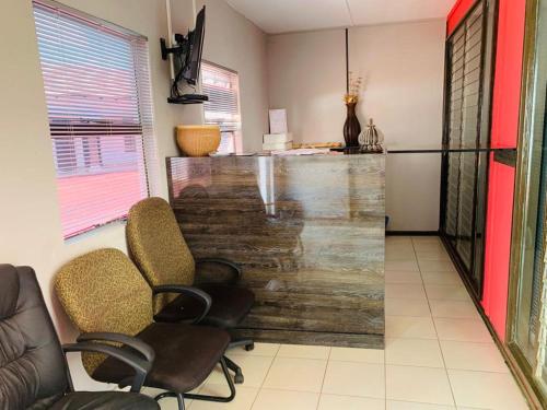 a lobby with chairs and a bar with a counter at Venice royal lodge in Thohoyandou