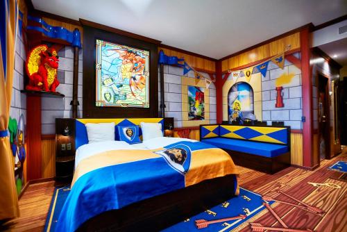 een slaapkamer met 2 bedden in een kamer met een muurschildering bij LEGOLAND Castle Hotel in Billund