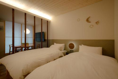 a bedroom with two beds and a table with a table at so, KANAZAWA in Kanazawa
