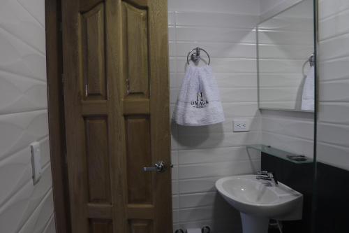 a small bathroom with a sink and a mirror at Hotel Omaga El peñol- Guatape in El Peñol