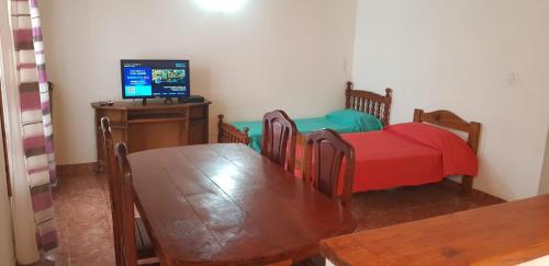 comedor con mesa y TV en Departamentos Amoblados Nqn en Neuquén