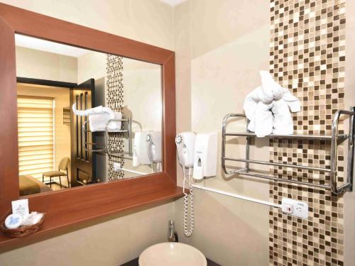 a bathroom with a mirror and a sink with towels at Hotel Montecarlo in Ibarra