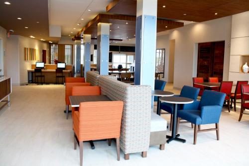 a waiting area with tables and chairs and tablesktop at Holiday Inn Express & Suites Duluth North - Miller Hill by IHG in Duluth