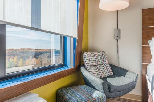 ein Schlafzimmer mit einem Stuhl und einem Fenster in der Unterkunft Holiday Inn Express & Suites Clarion, an IHG Hotel in Clarion