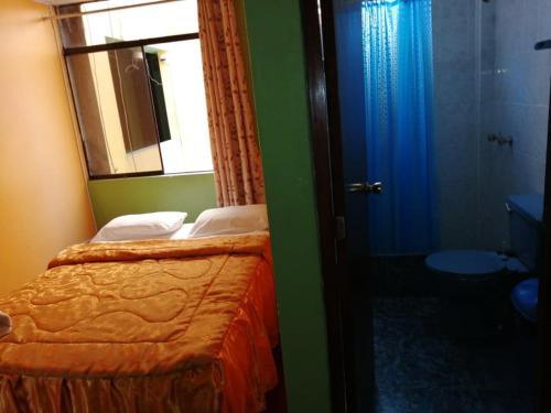 a bedroom with a bed and a mirror and a bathroom at Hospedaje El Arca in Lima