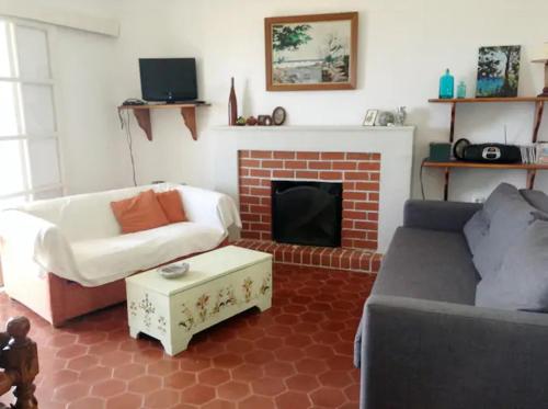 Beach House في زاغورا: غرفة معيشة مع أريكة ومدفأة