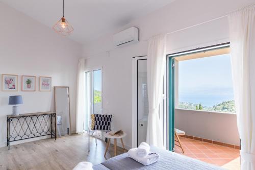 Villa Bella Vista Corfu في كاسيوبي: غرفة نوم مع سرير وإطلالة على المحيط