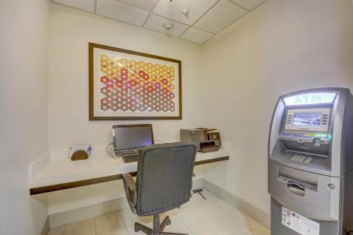 an office with a desk with a computer and a printer at Holiday Inn Express Hotel & Suites Tampa-USF-Busch Gardens by IHG in Tampa