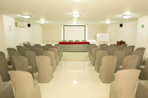 a conference room with chairs and a screen in the background at Hotel Buena Vista Express in Bucaramanga