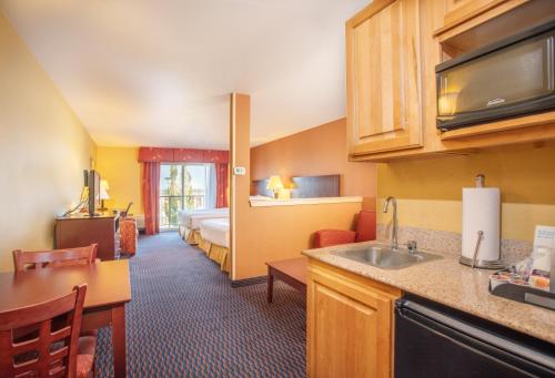 a hotel room with a kitchen and a bedroom at Holiday Inn Express Hotel & Suites Richland in Richland