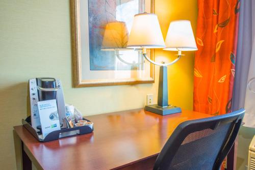 a desk with a lamp and a coffee maker on it at Holiday Inn Express Hotel & Suites Richland in Richland
