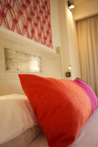 a red pillow sitting on top of a bed at Solana Beach Mauritius - Adults Only in Belle Mare