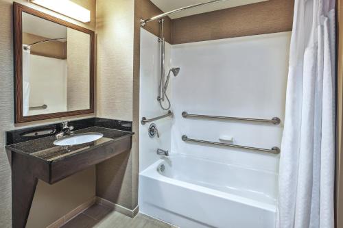 ein Badezimmer mit einem Waschbecken und einer Badewanne in der Unterkunft Holiday Inn Express & Suites Dayton South - I-675, an IHG Hotel in Shanersville