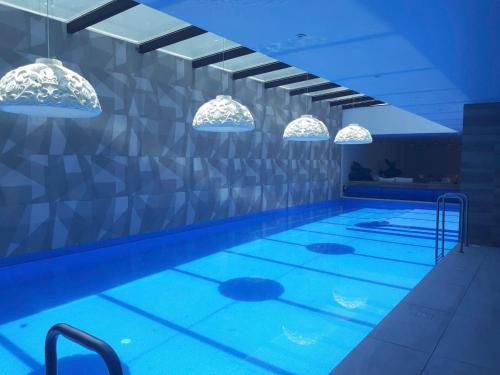 a swimming pool with blue lighting in a building at ONE Luxury Suite Super King Bed & Volcano View in Quito