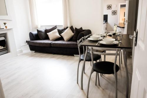 a living room with a table and a couch at 4 Bedroom House- Close to City Centre- Ideal for Contractors- Free Parking- Sleeps 8 in Stoke on Trent