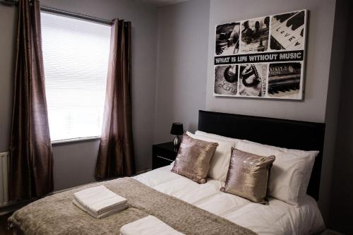 a bedroom with a bed with pillows and a window at 4 Bedroom House- Close to City Centre- Ideal for Contractors- Free Parking- Sleeps 8 in Stoke on Trent