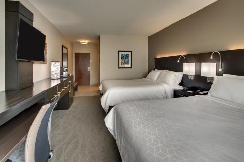 a hotel room with two beds and a flat screen tv at Holiday Inn Express & Suites Lancaster East - Strasburg by IHG in Strasburg