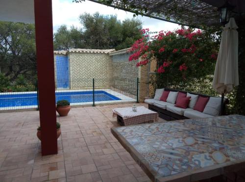 貝納盧普卡薩斯維耶哈斯的住宿－Las Lagunetas del sur，一个带沙发和桌子的庭院和一个游泳池