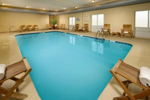 una grande piscina con due sedie in una stanza d'albergo di Holiday Inn Express Hotel & Suites Lenoir City Knoxville Area by IHG a Lenoir City