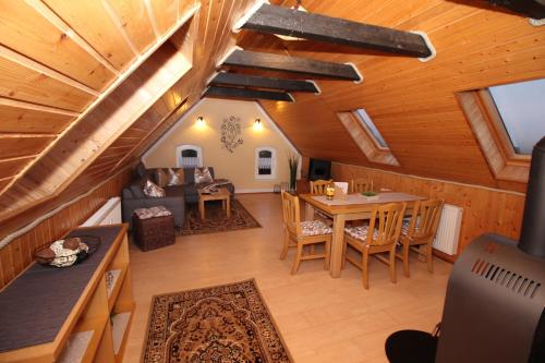 a living room with a wooden ceiling and a table at Gutshof Kämmerich - Fewo "Siebenschläferhöhle" in Altkalen
