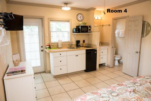 a kitchen with white cabinets and white appliances at Haley's at Anna Maria Island Inn in Holmes Beach