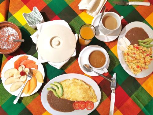 a table with plates of food and cups of coffee at Hotel La Estancia in Río Verde