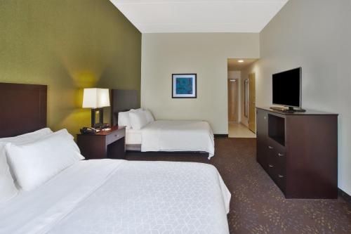a hotel room with two beds and a flat screen tv at Holiday Inn Express & Suites Geneva Finger Lakes by IHG in Geneva