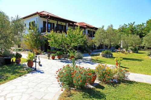 a house with a garden with potted plants and trees at Dionysus Apartments & Suites in Ierissos