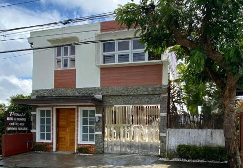 una casa con un árbol delante de ella en Pensio de Felipe, en Tagaytay