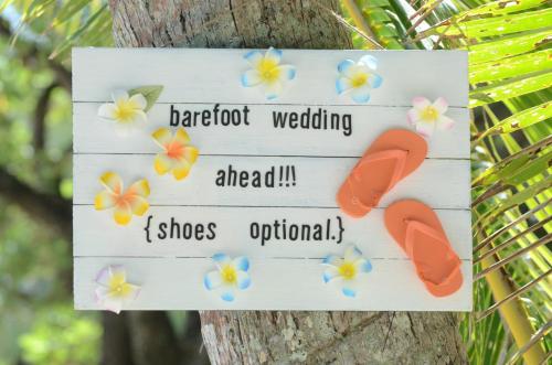 a sign on a tree with shoes on it at Sanctuary Rarotonga on the Beach (Adults Only) in Rarotonga