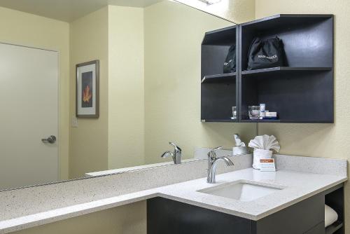 a bathroom with a sink and a mirror at Candlewood Suites Bloomington, an IHG Hotel in Bloomington