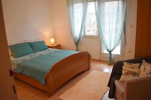 a bedroom with a bed and a couch and a window at Apartment Lavanda in Fažana