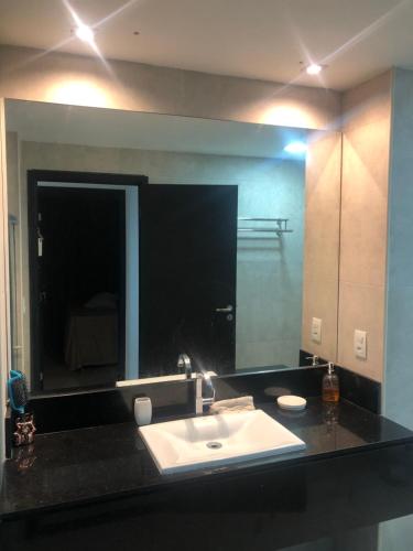 baño con lavabo y espejo grande en Barra Home stay 22 andar, en Recife