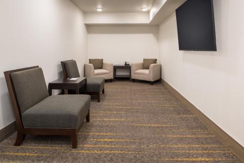 a waiting room with chairs and a tv on a wall at Staybridge Suites - Hillsboro North by IHG in Hillsboro