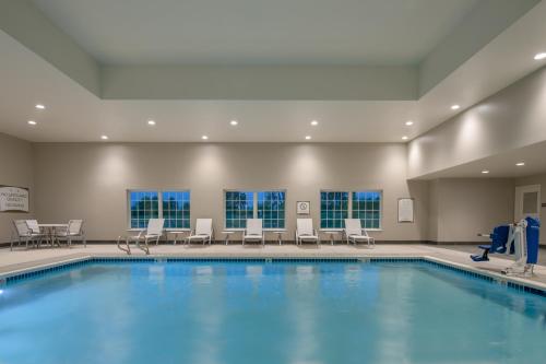 una piscina con sillas y una mesa en Staybridge Suites - Hillsboro North, an IHG Hotel en Hillsboro