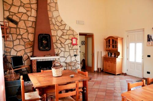 ein Wohnzimmer mit einem Tisch und einem Steinkamin in der Unterkunft La Masseria di Villa Giulia in Tocco da Casauria