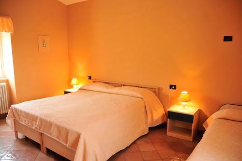 a bedroom with two beds and two lamps on tables at La Masseria di Villa Giulia in Tocco da Casauria