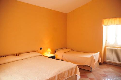 two beds in a room with orange walls at La Masseria di Villa Giulia in Tocco da Casauria