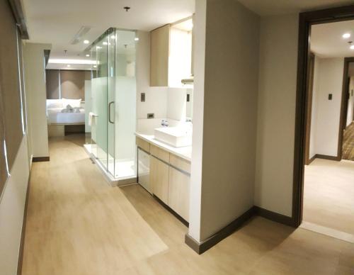 a kitchen with a white refrigerator and a white sink at The Mini Suites - Eton Tower Makati in Manila