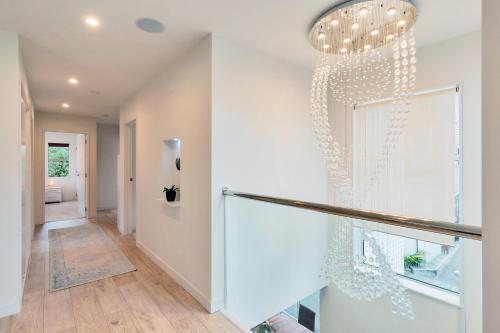 a staircase in a house with a chandelier at Elegant and Stylish Retreat in Leafy Epsom in Auckland