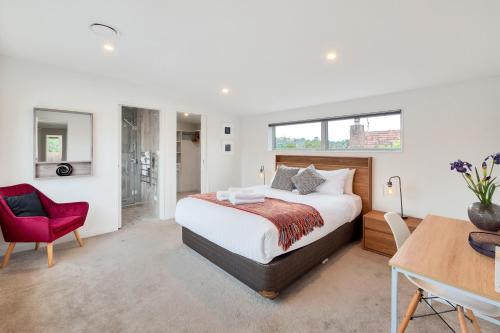 a bedroom with a bed and a desk and a chair at Elegant and Stylish Retreat in Leafy Epsom in Auckland