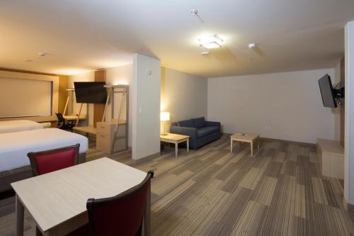 een hotelkamer met een bed, een bank en een tafel bij Holiday Inn Express & Suites Port Huron, an IHG Hotel in Port Huron