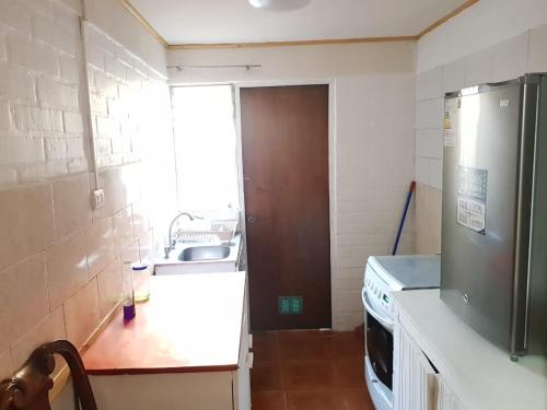 a small kitchen with a sink and a refrigerator at CASA GUADALUPE SAN FELIPE in San Felipe