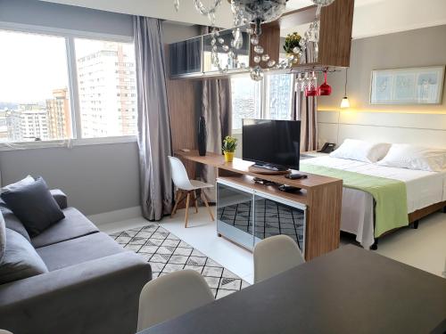 a bedroom with a bed and a desk with a television at STD - Anora Spaces - Stadium Alphaville in Barueri