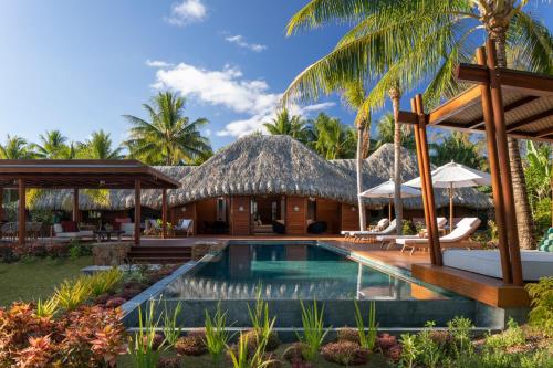 a villa with a swimming pool and a resort at Four Seasons Resort Bora Bora in Bora Bora