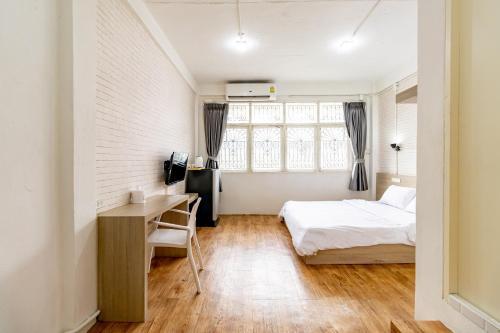 Ze Residence Bang Aor Station في بانكوك: غرفة نوم مع سرير ومكتب