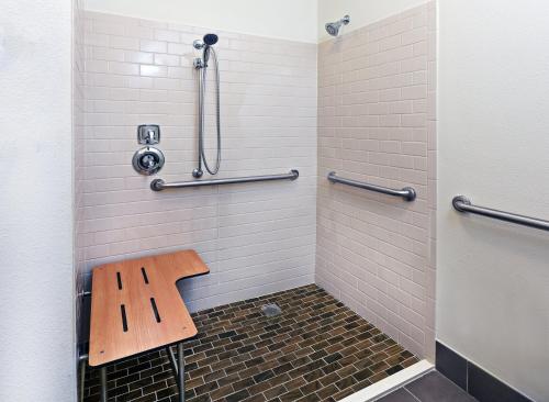 y baño con ducha y banco de madera. en Candlewood Suites San Angelo, an IHG Hotel, en San Angelo
